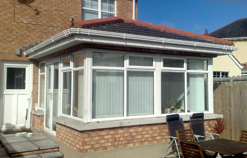 Large white uPVC sunroom with a tiled roof