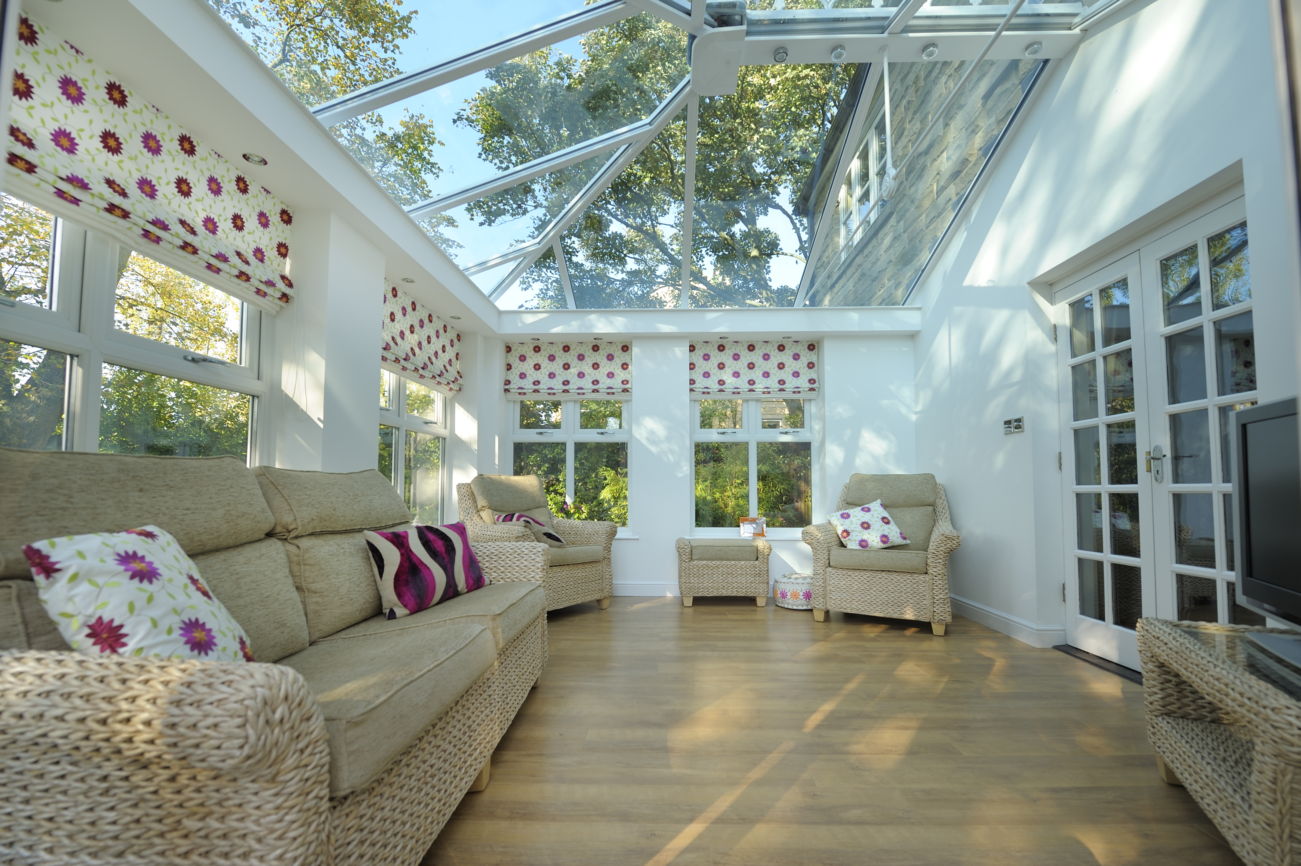 Inside a white conservatory with a glass roof.